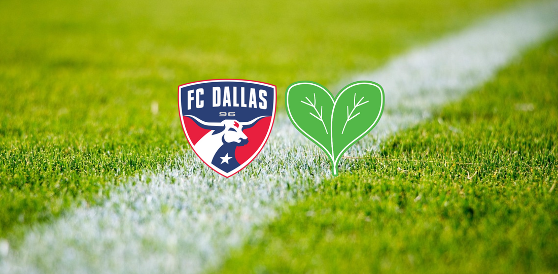 A close up of a soccer field with the FC Dallas soccer team logo and two green leaves forming a heart 